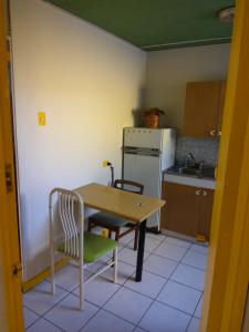 安托法加斯塔Resimed的厨房配有桌子、两把椅子、一张桌子和一台冰箱