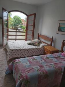 大伊瓜巴Vivendas de Iguaba的带窗户的客房内的两张床