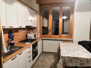 Miroglioda Alessandra e Fabio的小厨房配有白色橱柜和水槽