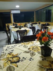 马拉戈日Pousada Gamela do Maragogi的用餐室配有桌椅和鲜花