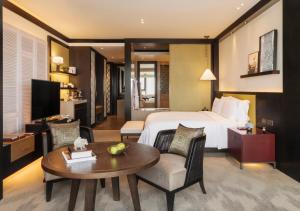 金边金边瑰丽酒店的酒店客房配有一张床铺和一张桌子。