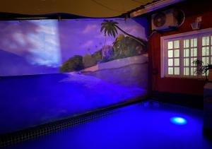 佩鲁伊比Peruibe Centro e Mar 940的蓝色灯光的房间,设有游泳池