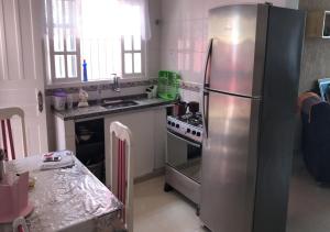 佩鲁伊比Peruibe Centro e Mar 940的厨房配有不锈钢冰箱和炉灶。
