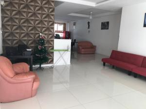 峇六拜Island Hostel的客厅配有2把红色椅子和圣诞树