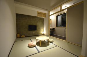 由布市Yufuin Tsuru no Yu的小房间设有桌子和电视