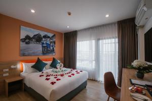 班敦孟7 Days Premium Hotel Don Meaung Airport的酒店客房的床铺上摆放着玫瑰花