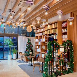 安阳市CS总理酒店的一个带圣诞树和桌椅的图书馆