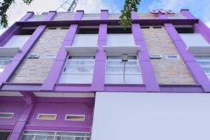 班达亚齐SUPER OYO Capital O 2018 Ring Road Guest House Syariah的紫色的建筑,上面有小猫的标志