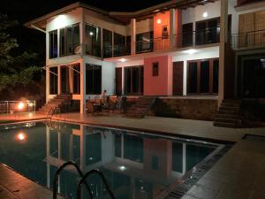 佩勒代尼耶Lotus Villa Kandy的一座晚上设有游泳池的房子