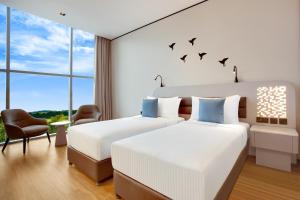 迪拜Lemon Tree Hotel, Jumeirah Dubai的两张床位于酒店客房,墙上有鸟类