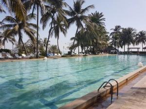 达喀尔达喀尔翡翠花园酒店的一座棕榈树环绕的大型游泳池