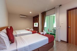 普吉镇普吉岛缇帕蒂酒店的酒店客房设有两张床和一张桌子。