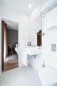 里斯本LX SoHo Boutique Hotel by RIDAN Hotels的白色的浴室设有水槽和镜子