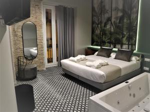 瓦伦西亚YOU & CO. Quart Boutique的一间卧室配有一张床和一个水槽和一个浴缸