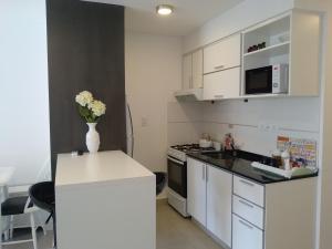 布兰卡港La Suitte的厨房配有白色橱柜和花瓶,位于柜台上