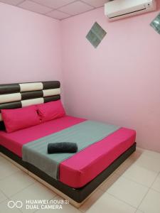 峇株巴辖LAYLA INN的粉红色和蓝色的房间里一张床位