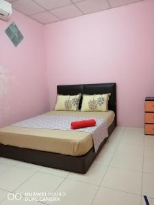 峇株巴辖LAYLA INN的粉红色墙壁的房间里一张床位