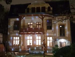 柏林酷尔孜别墅酒店的夜晚有灯的大白色房子