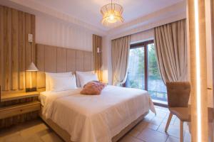 美特索文Adryades luxury apartments的一间卧室设有一张大床和一个窗户。