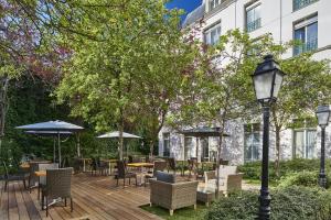 巴黎莫迪利亚尼别墅蓝色假日酒店的一个带桌椅和遮阳伞的木制甲板