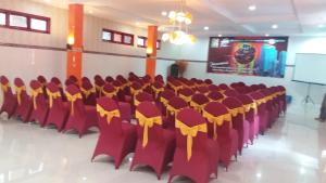 庞越Hotel Surya Utama - Syariah的一个带红色椅子和黄色弓的会议厅
