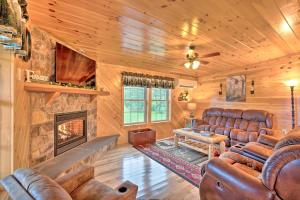 BenezetteRustic Benezette Cabin Porch, Hot Tub and Fire Pit的客厅配有皮革家具和壁炉