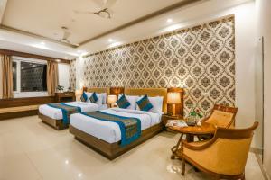 新德里Hotel Almati Inn at Delhi Airport的酒店客房设有两张床和一张桌子。