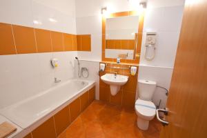布拉迪斯拉发伯拉第斯拉瓦布鲁酒店的带浴缸、卫生间和盥洗盆的浴室