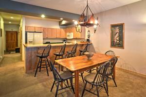 布雷肯里奇Mountain Condo Half Mi to Breckenridge Ski Slopes的厨房以及带木桌和椅子的用餐室。