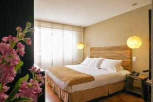 波哥大Hotel Retiro 84 by MIJ的酒店客房设有床和窗户。