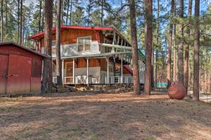 鲁伊多索Ruidoso Cabin with Forest Views and Covered Porch的树林中的一座房子,有一个红色谷仓