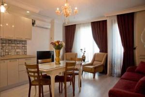 伊斯坦布尔Nupelda Residence Hotel的厨房以及带桌椅的起居室。