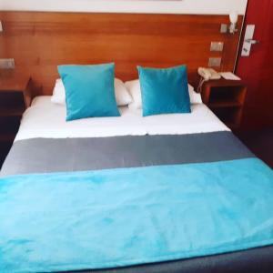 利纳雷斯Hotel Real的卧室内的一张带蓝色枕头的大床