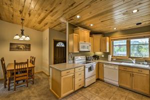 格兰德莱克Cozy Condo with Mtn Views and Deck Walk to Grand Lake的一间带木制天花板和桌子的厨房以及一间用餐室