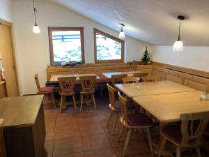 圣安东阿尔贝格Chalet Elfie的餐厅设有木桌、椅子和窗户。
