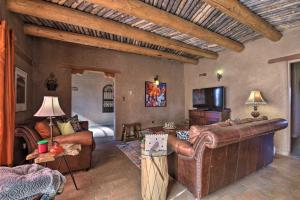 El PradoEl Prado Adobe Home Courtyard with Mountain Views!的一间带真皮沙发的客厅和一间带床的房间