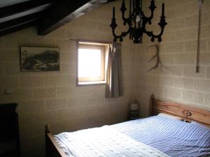 斯塔沃洛Le Vieux Sart 32 Coo的一间卧室配有一张带窗户和吊灯的床。