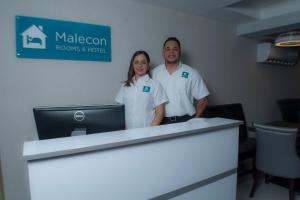 圣多明各Malecon Premium Rooms & Hotel的站在前台旁边的男女