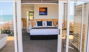 新普利茅斯环形路海滨假日公园酒店的一间卧室配有一张床,享有海景