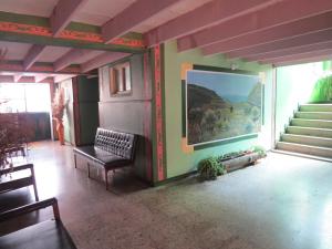 蒙圭Hotel Portón De Ocetá的客厅的墙上和楼梯上都装饰着绘画作品
