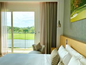北榄Eastin Thana City Golf Resort Bangkok的酒店客房设有一张床和一个大窗户