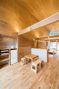 八王子市Mt.Takao Base Camp的厨房设有木墙、桌子和长凳