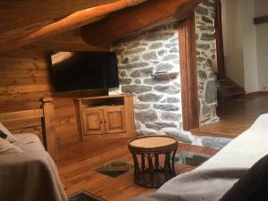 Val CenisChalet Alpin的客厅设有石头壁炉及电视