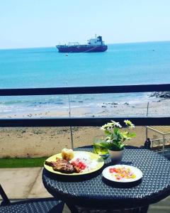 伊洛Departamento vista al mar的海滩上一张桌子,上面放着两盘食物