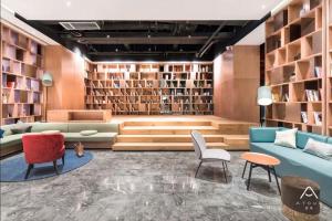 宁波宁波机场鄞州大道亚朵酒店的带沙发、椅子和书架的图书馆