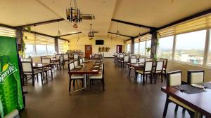 奇克马格尔Hotel Blue Pearl Chikmagalur的用餐室设有桌椅和窗户。