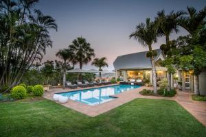 内尔斯普雷特洛瑞的呼唤旅馆的一个带游泳池和棕榈树的后院