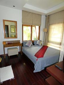象岛海滩公寓的一间卧室配有一张带书桌和镜子的床