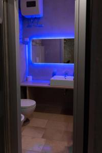 科拉托Graffiti B&B Apartments的一间带水槽的浴室和蓝色灯光的卫生间