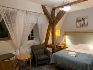 缅济热奇维拉斯塔罗斯提酒店的卧室配有床、椅子和窗户。